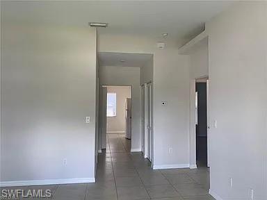 Corridor with tile patterned floors and baseboards