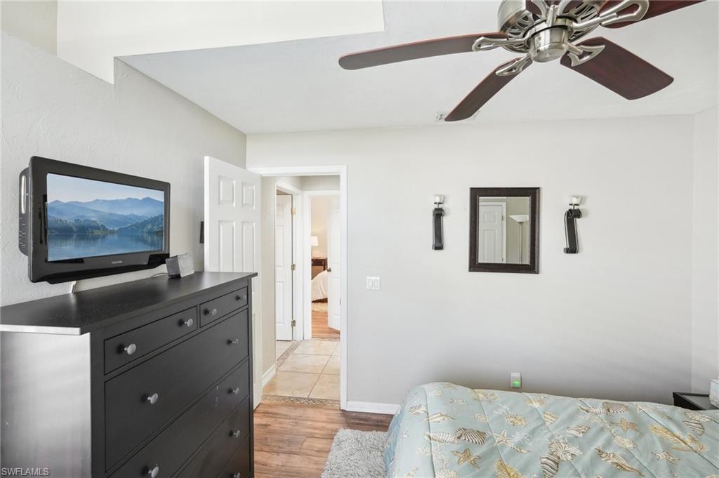 Bedroom featuring light wood-type flooring, a ceiling fan, and baseboards