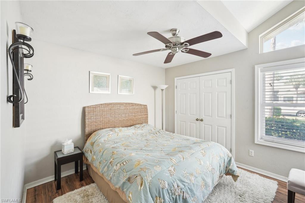 Bedroom with a closet, wood finished floors, a ceiling fan, and baseboards