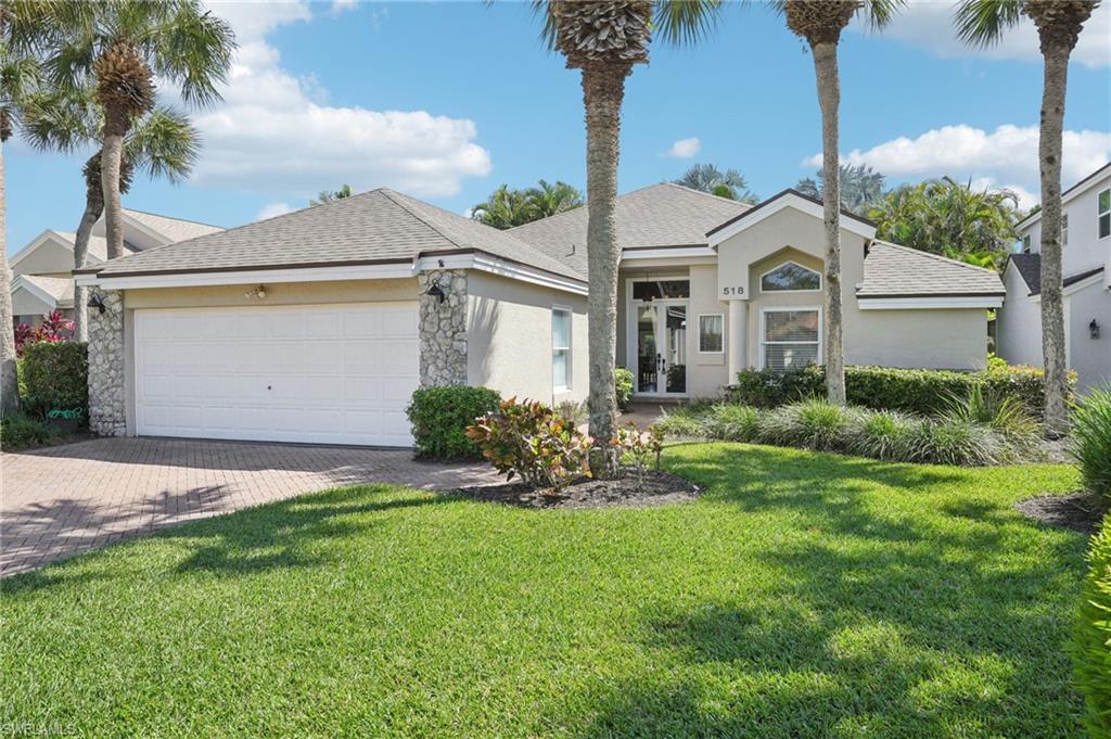 View of front facade with a garage, a shingled roof, decorative driveway, stucco siding, and a front lawn