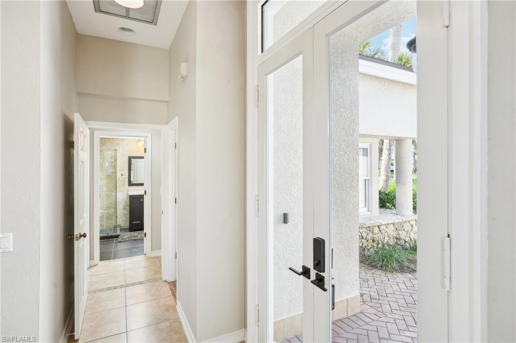 Hall featuring tile patterned floors, baseboards, and french doors