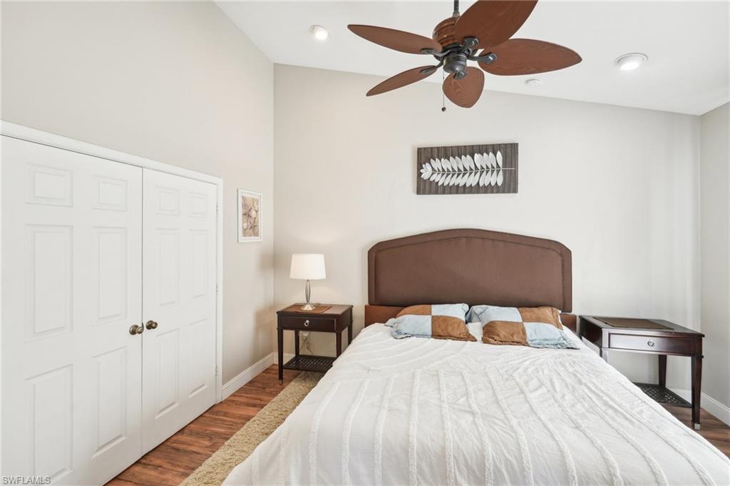 Bedroom featuring wood finished floors, a ceiling fan, baseboards, vaulted ceiling, and a closet