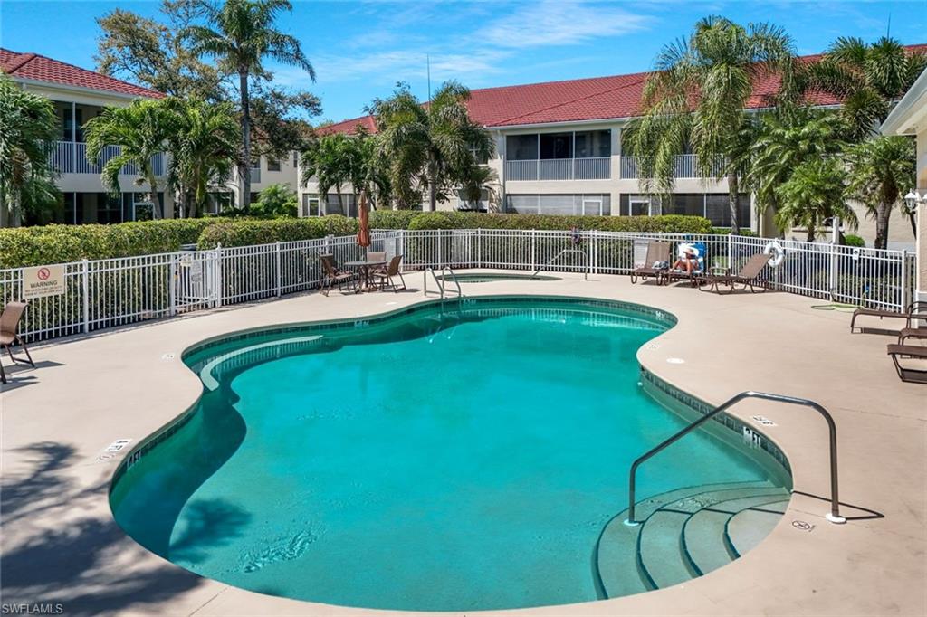Community pool featuring a patio and fence