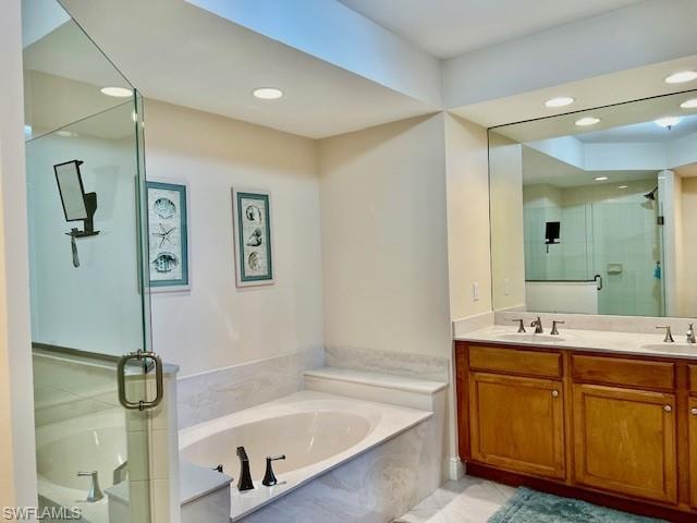 Bathroom featuring double vanity, a shower stall, a garden tub, and a sink