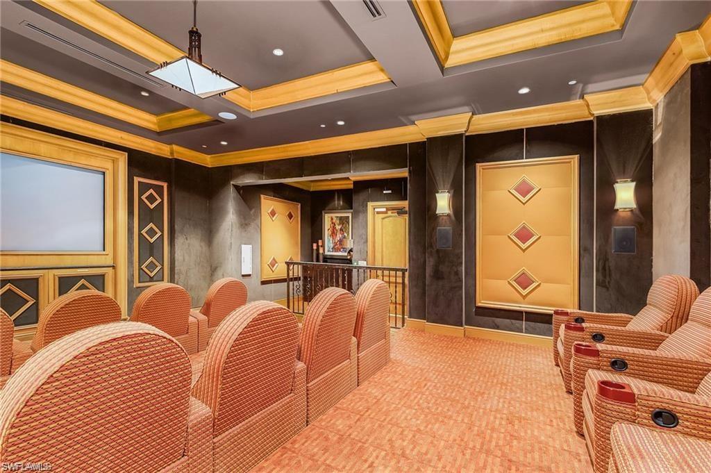 Home theater featuring visible vents, a raised ceiling, and ornamental molding