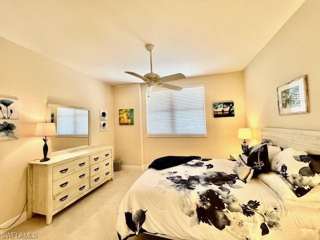 Bedroom with ceiling fan, baseboards, and light carpet