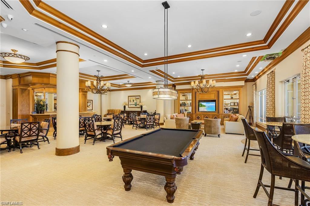 Recreation room with pool table, a tray ceiling, a notable chandelier, and carpet