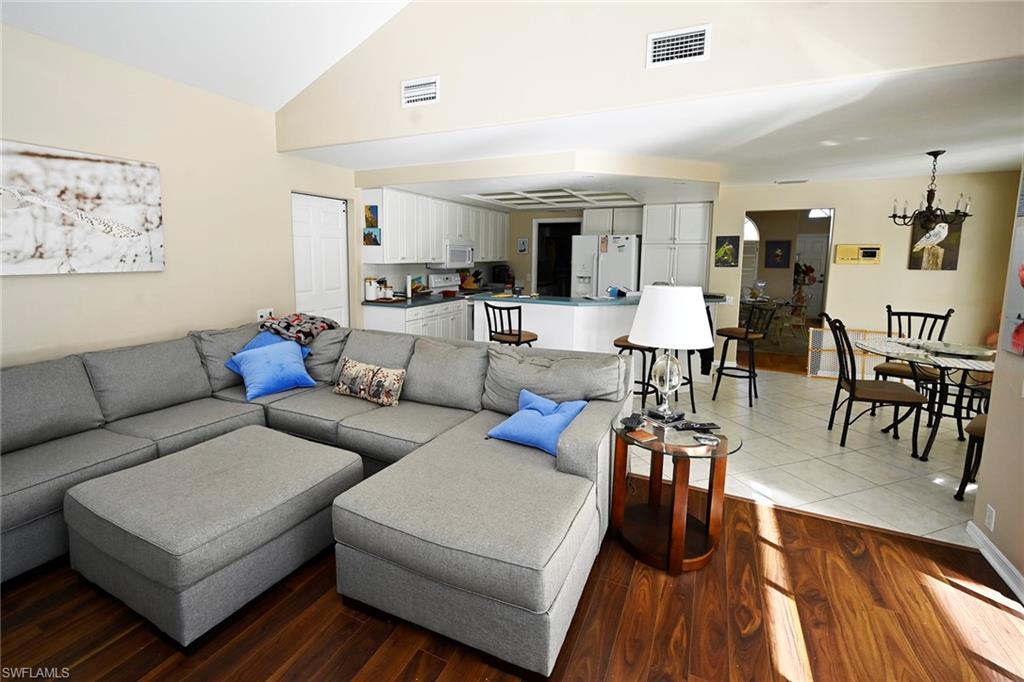 Living room featuring  lofted ceiling, and wood finished floors and is open to the kitchen.