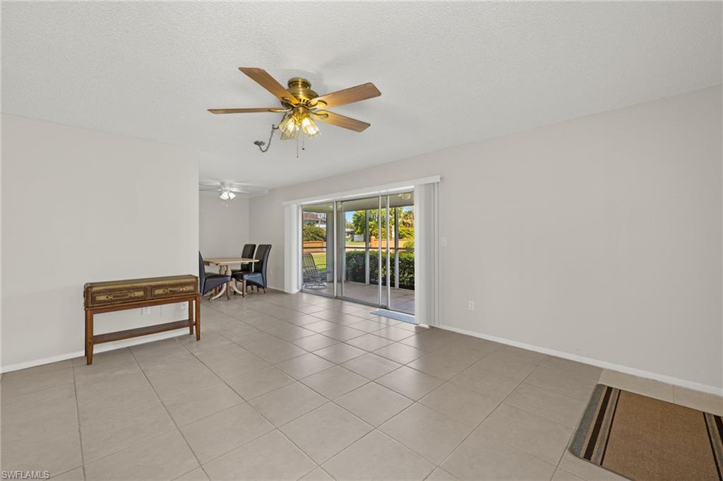 Spare room with ceiling fan, baseboards, a textured ceiling, and light tile patterned flooring