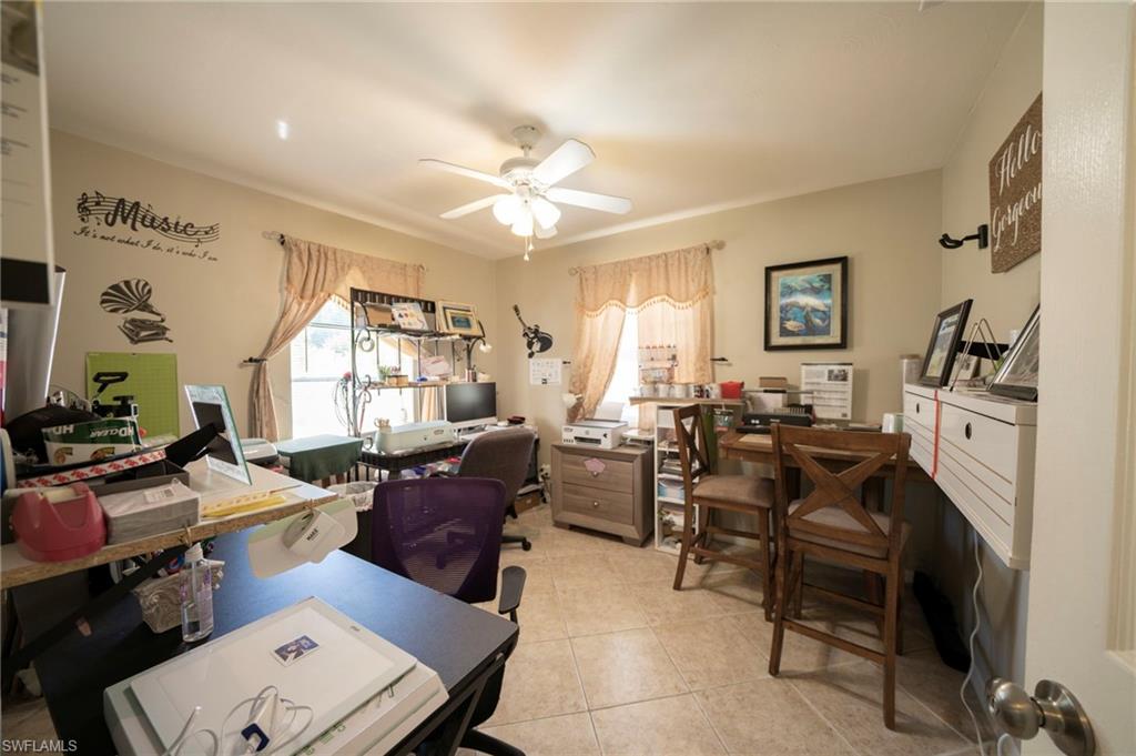 Office with light tile patterned floors and a ceiling fan