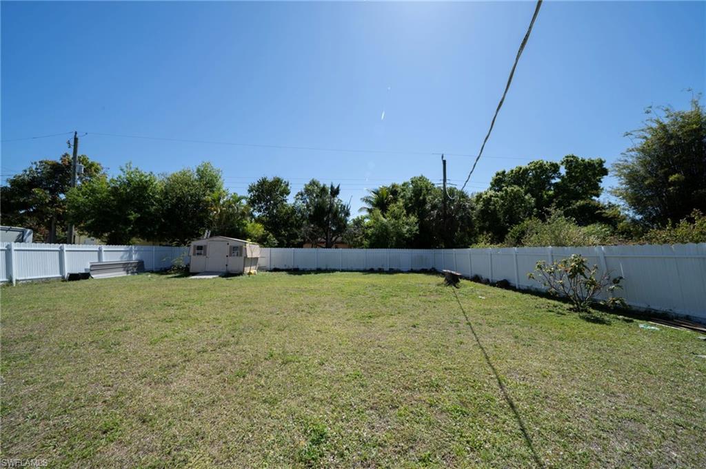 View of yard with a storage unit, an outdoor structure, and a fenced backyard