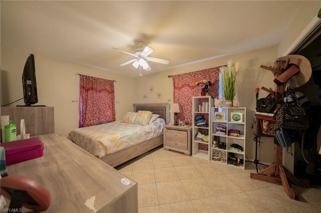 Bedroom featuring light tile patterned floors and ceiling fan
