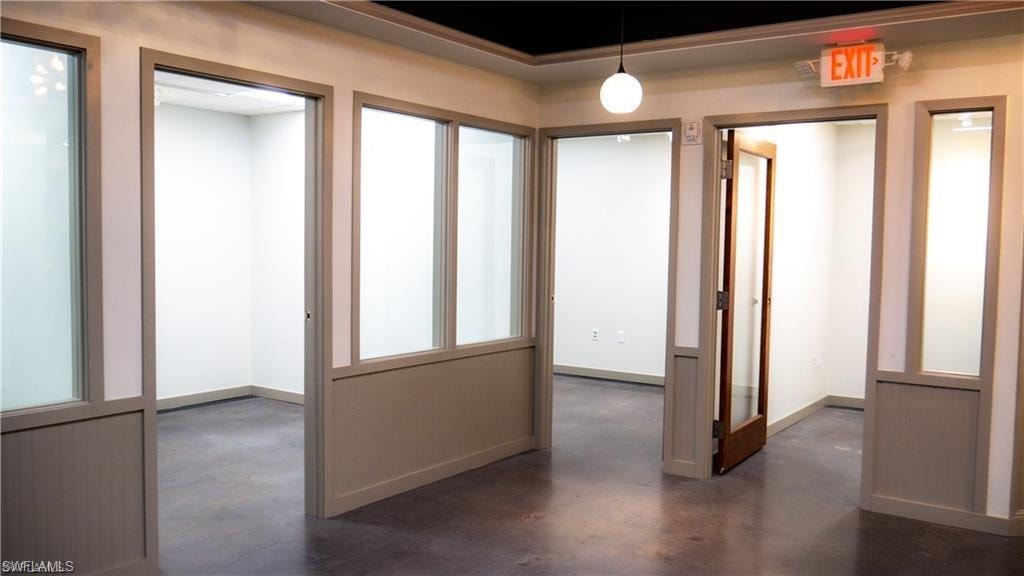 Hallway featuring finished concrete floors and baseboards