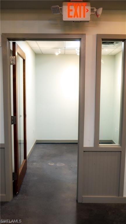 Hall featuring concrete floors and baseboards