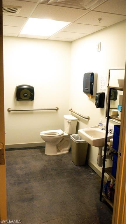 Private Bathroom with visible vents, baseboards, a sink, a paneled ceiling, and toilet