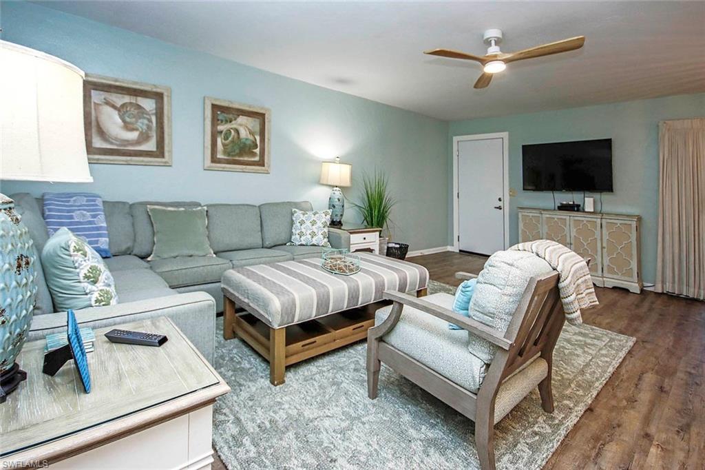 Living room with baseboards, ceiling fan, and wood finished floors