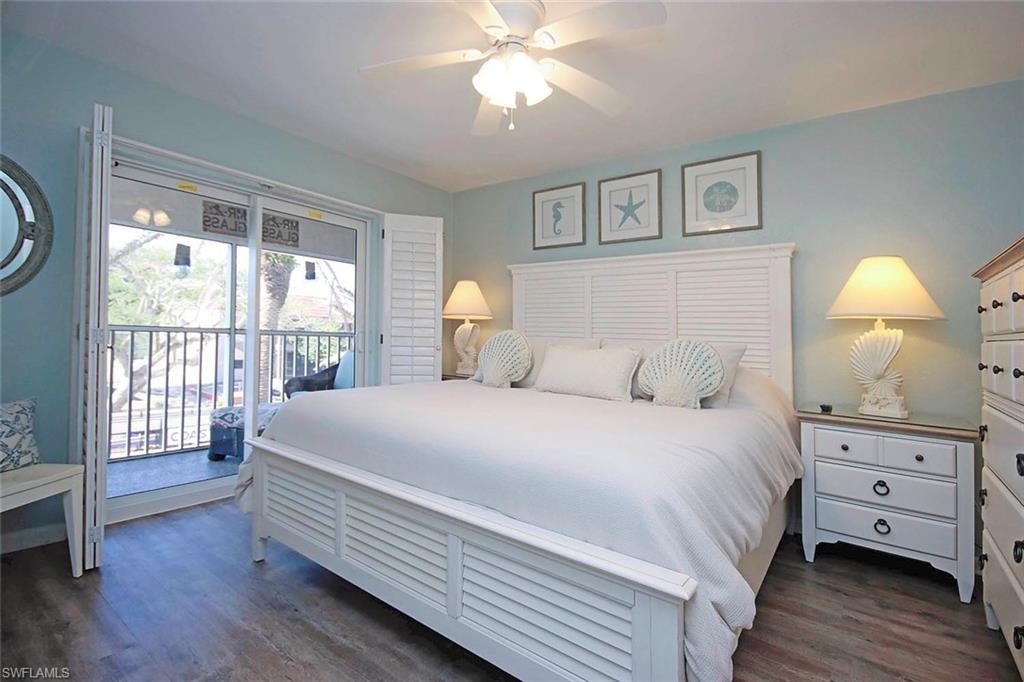 Bedroom with dark wood finished floors, access to exterior, and a ceiling fan