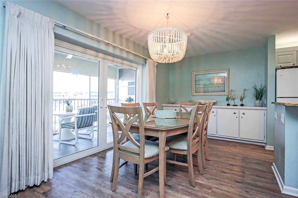 Dining space featuring an inviting chandelier, baseboards, and dark wood-type flooring