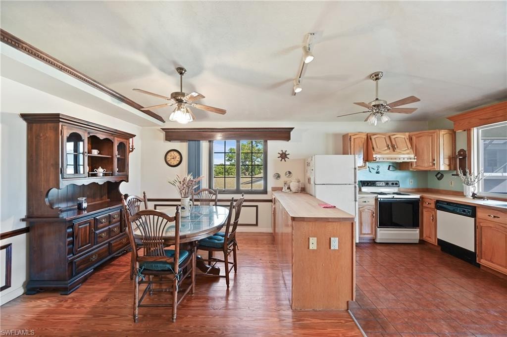 Kitchen with range with electric stovetop, wood counters, dishwasher, dark wood-style flooring, and track lighting