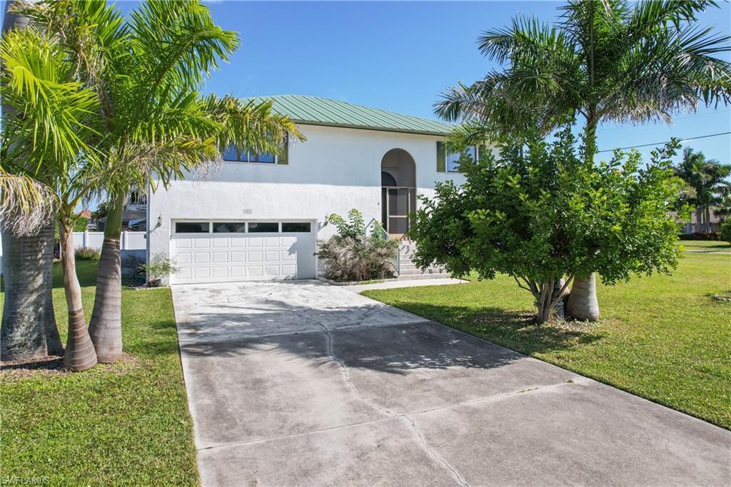 Mediterranean / spanish home with concrete driveway, stucco siding, a metal roof, a front yard, and a garage