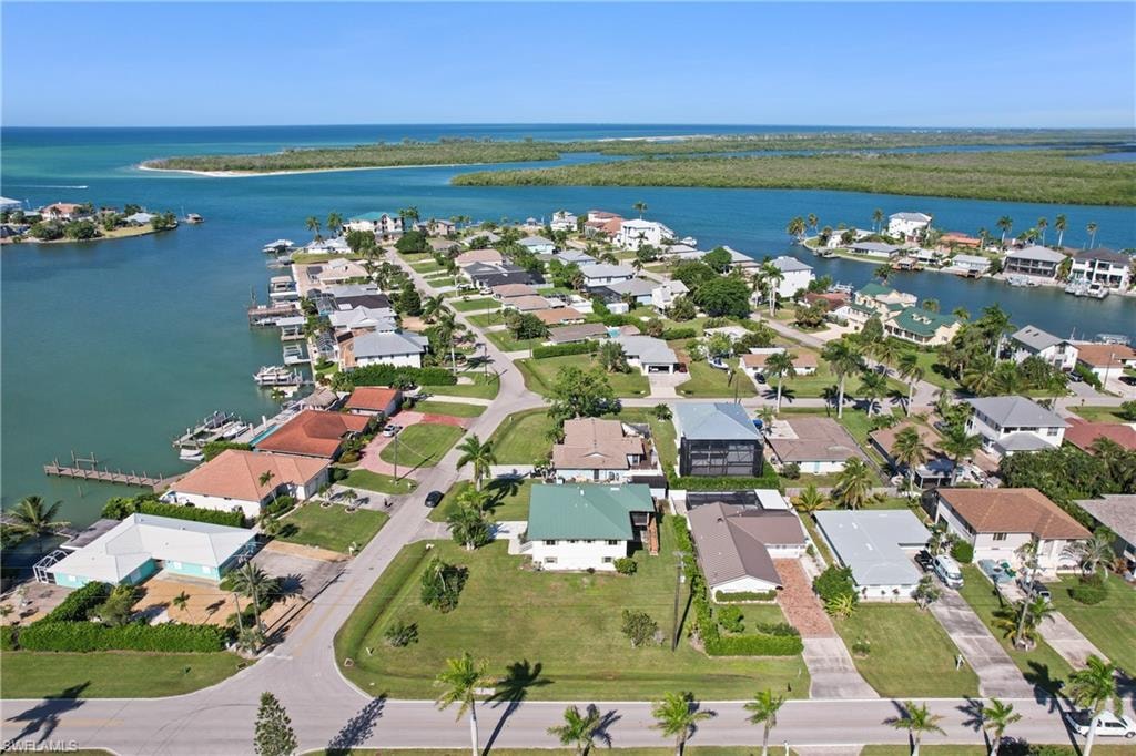 Aerial view of property and surrounding area with nearby suburban area and a nearby body of water