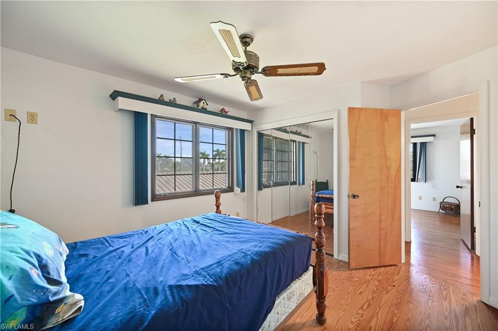 Bedroom with wood finished floors, a closet, and a ceiling fan