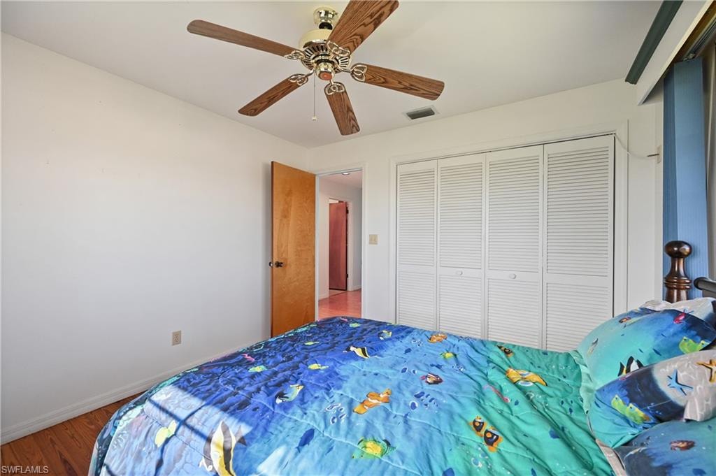 Bedroom featuring wood finished floors, ceiling fan, and a closet