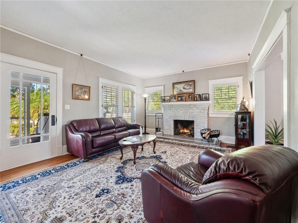 The heart of the home, this elegant living room features a working wood-burning fireplace, original hardwood flooring, and the timeless craftsmanship that defines this 1925 Colonial.