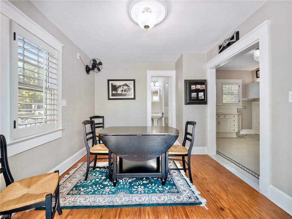 The dining room beautifully blends form and function, featuring original hardwood flooring, timeless craftsmanship, and a vintage oscillating fan that serves as both a conversation piece and a reminder of the home's heritage.