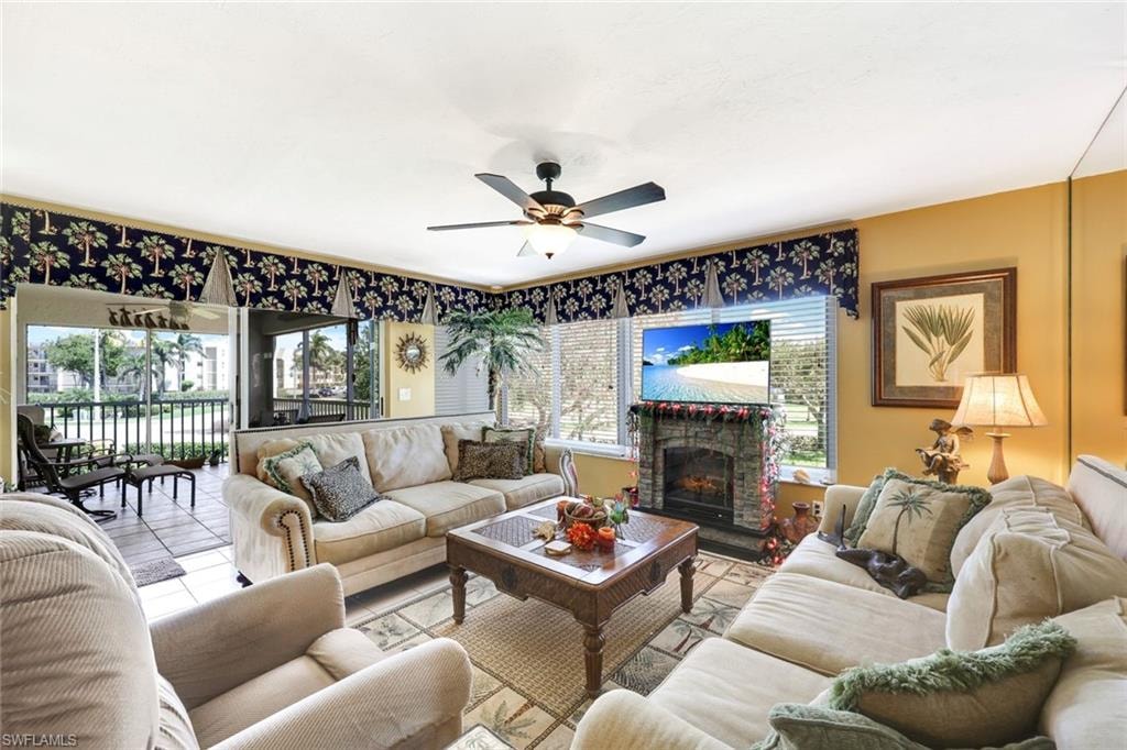 Tiled living room with a brick fireplace and a ceiling fan
