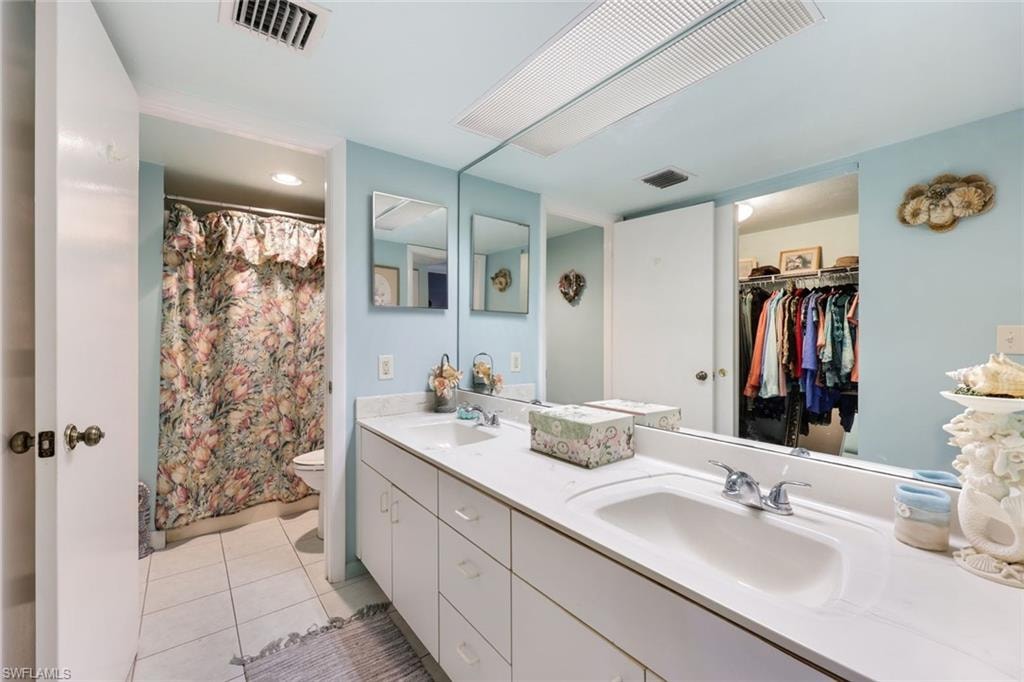 Bathroom with tile patterned flooring, visible vents, and a sink