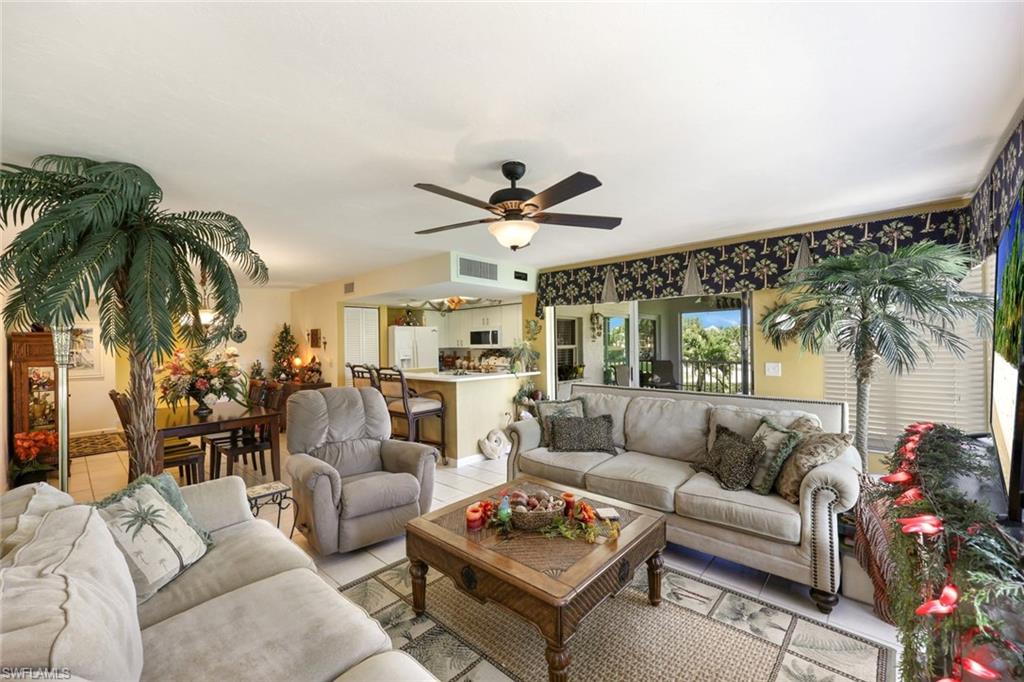 Living area featuring light tile patterned flooring, visible vents, and ceiling fan