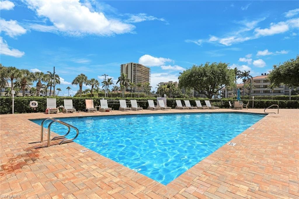 Community pool with a patio and fence