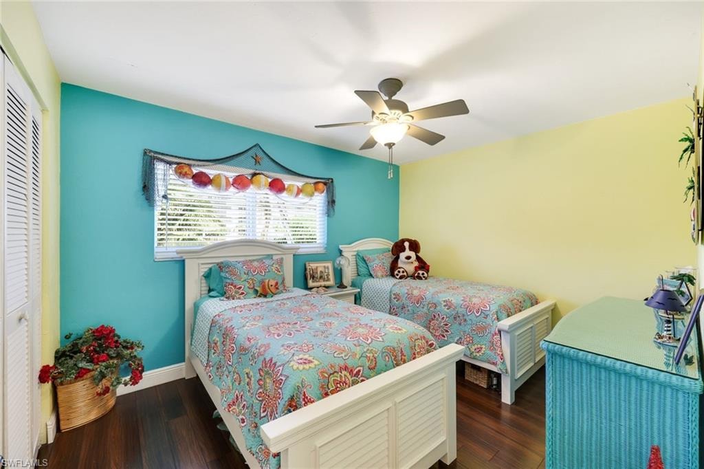 Bedroom featuring a ceiling fan, wood finished floors, a closet, and baseboards