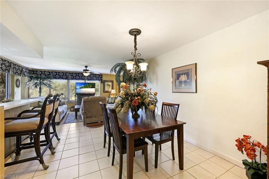 Dining space featuring light tile patterned floors, baseboards, and a chandelier