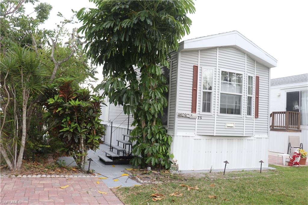 View of side of property with a lawn