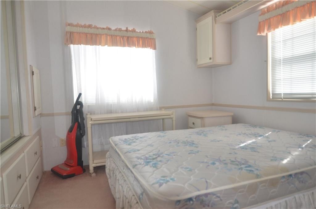 Bedroom featuring light carpet