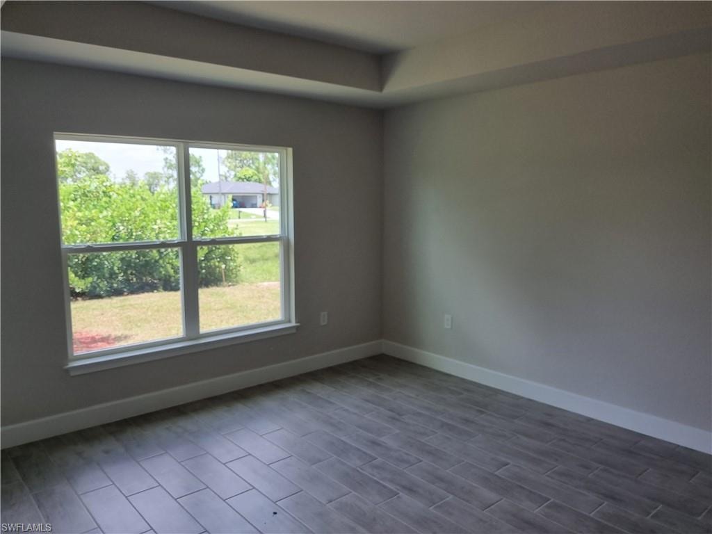 Unfurnished room featuring dark wood-style floors