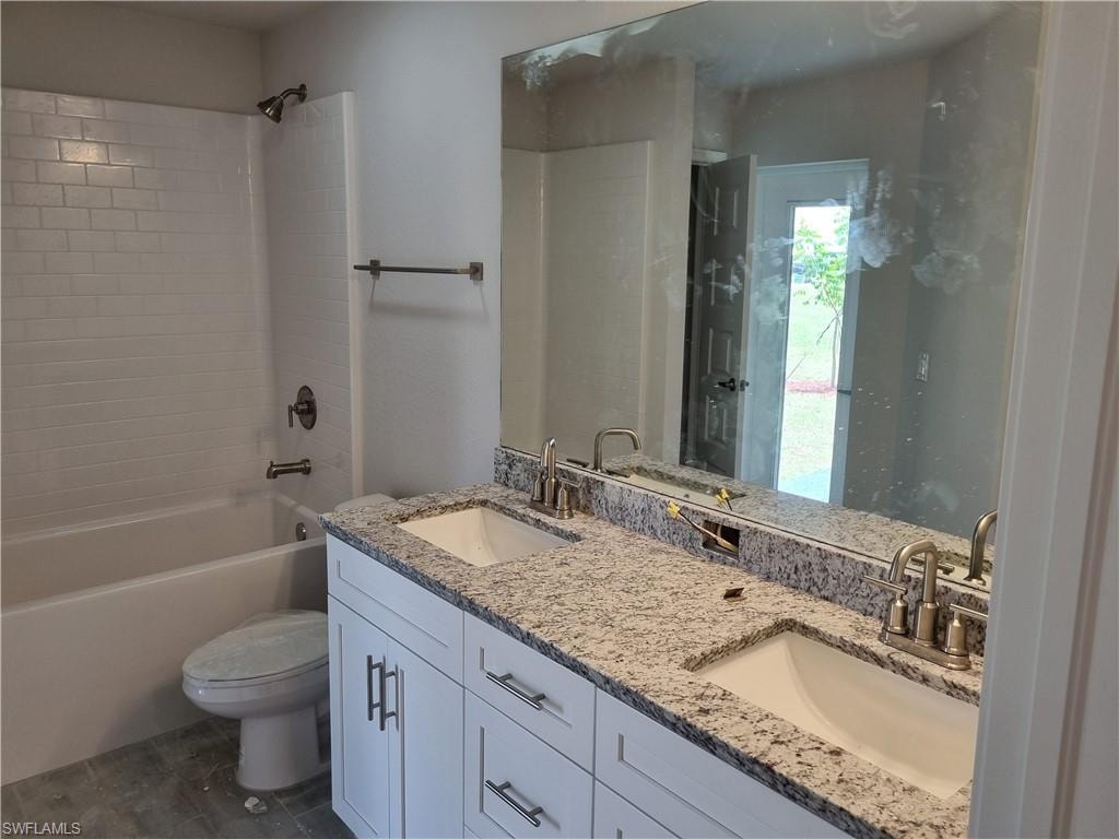 Bathroom featuring double vanity and shower / tub combination