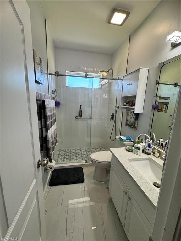 Bathroom with marble finish floor, toilet, a stall shower, and vanity