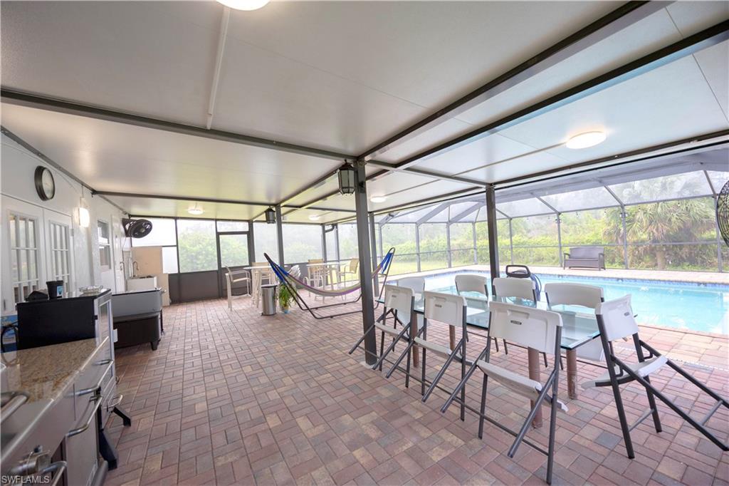 View of patio / terrace featuring an outdoor pool and glass enclosure