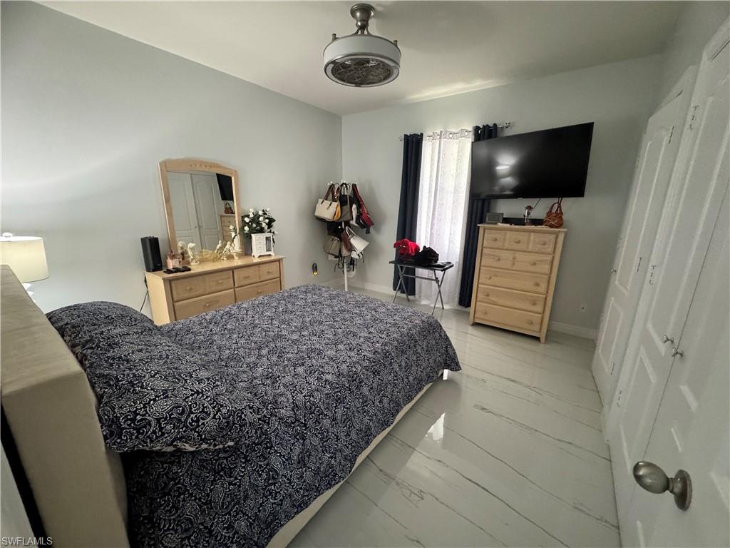 Bedroom featuring baseboards and marble finish floor