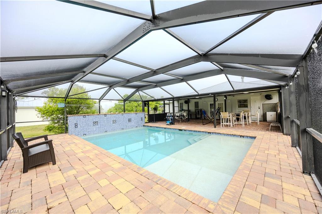 Pool with a patio and glass enclosure