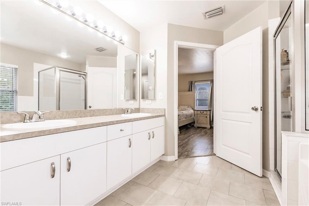 Ensuite bathroom featuring double vanity, double sinks and a large shower stall
