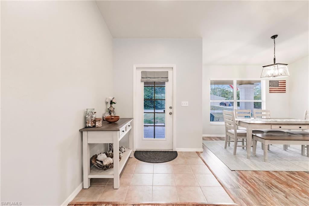 Entryway with light tile patterned floors,  and a chandelier