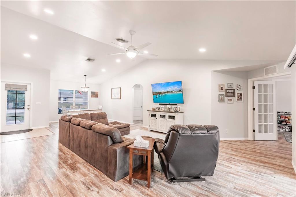 Living area with arched walkways, ceiling fan, french doors and open floor plan