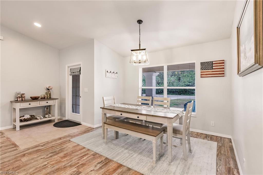 Dining space featuring light wood finished floors, baseboards, and a notable chandelier