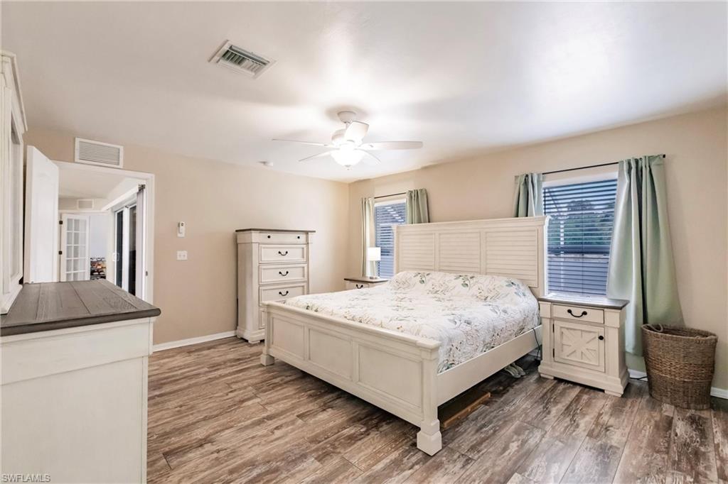 Bedroom with multiple windows, and wood finished floors