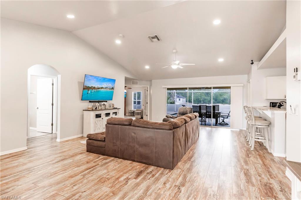 Living area featuring  light wood-style floors, cathedral ceiling, recessed lighting and a ceiling fan