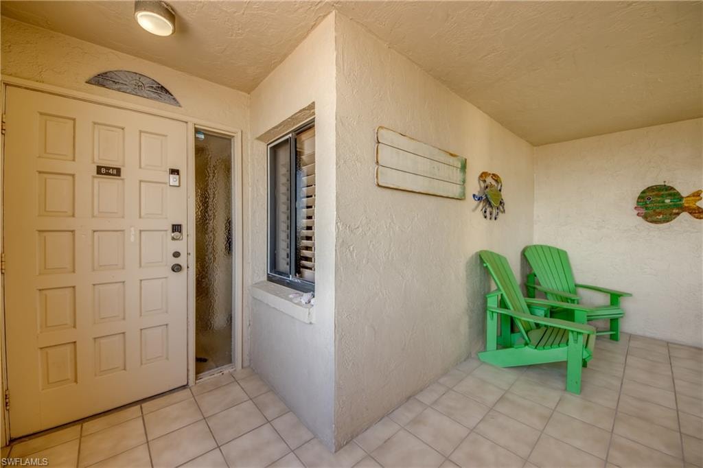Screened in front porch looking at front door to unit
